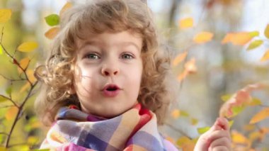 Mutlu çocuk sonbahar parkında dışarıda oynuyor.