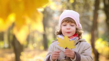 Mutlu çocuk sonbahar parkında dışarıda oynuyor.
