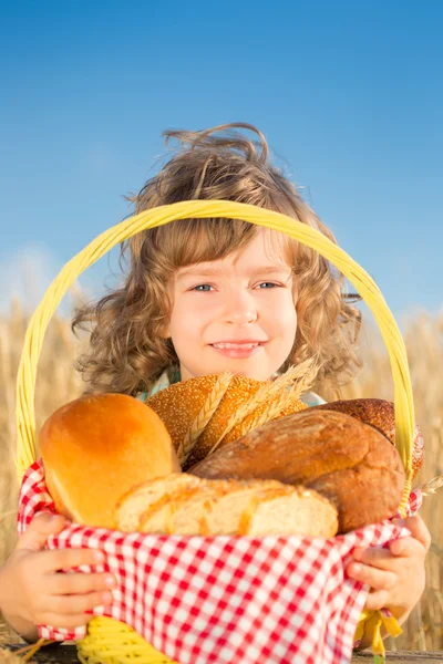 Boldog gyermek kenyér kosárban — Stock Fotó