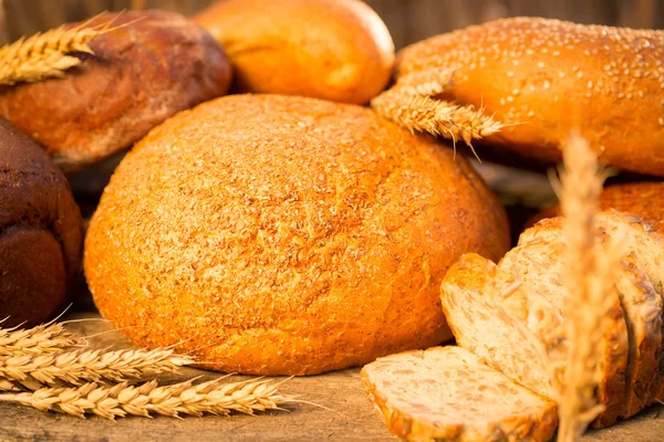 Σπιτικό ψωμί και σιτάρι στο ξύλινο τραπέζι — Φωτογραφία Αρχείου