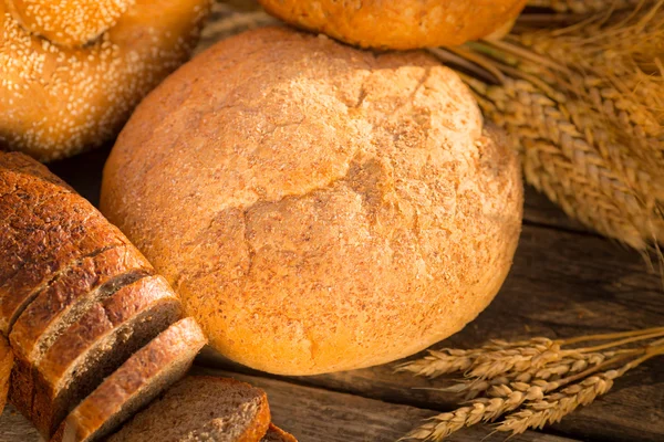 Домашній хліб і пшениця на дерев'яному столі — стокове фото