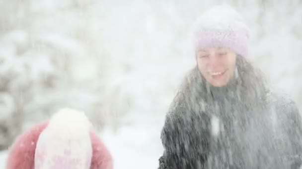 Woman and child playing with snow in winter — Stock Video