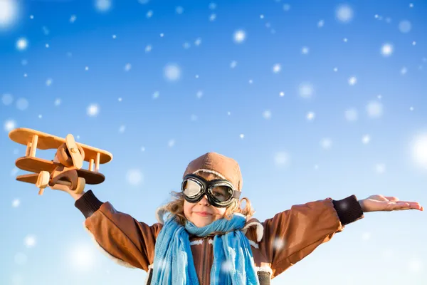 Criança feliz brincando com avião de brinquedo no inverno — Fotografia de Stock