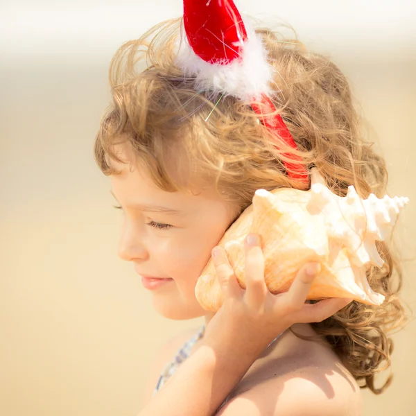 Child in Santa hat at the beach — Stock Photo, Image