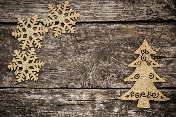 Guld julgran dekorationer på grunge trä — Stockfoto
