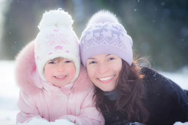 Familia feliz tendida en la nieve —  Fotos de Stock