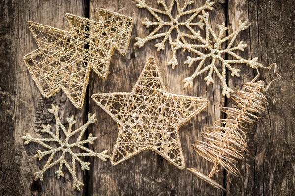 Gold Christmas tree decorations on grunge wood — Stock Photo, Image