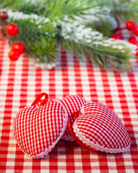 Decorações de árvore de Natal e ramo na toalha de mesa de gingham vermelho — Fotografia de Stock