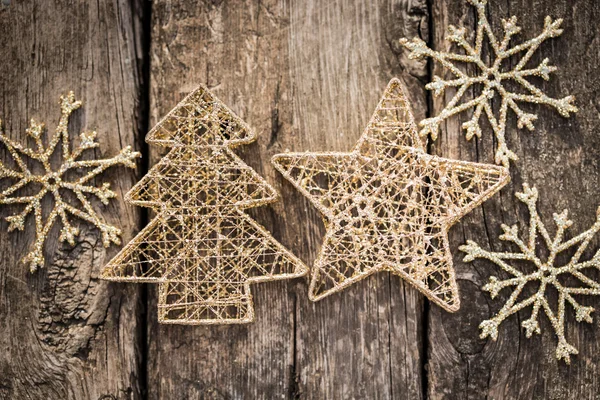 Gold Christmas tree decorations on grunge wood — Stock Photo, Image