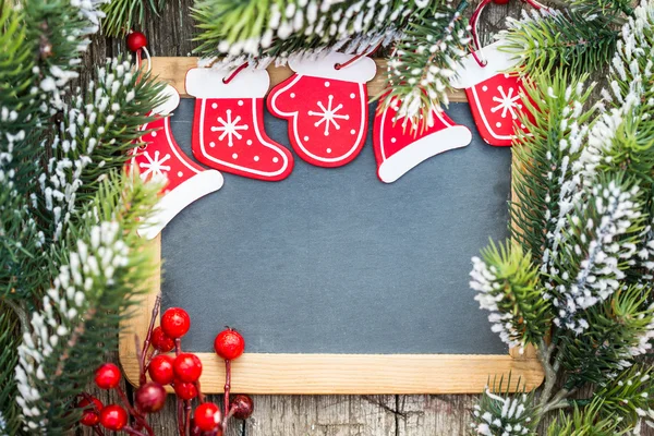 Blackboard blank framed in beautiful Christmas tree branches and — Stock Photo, Image