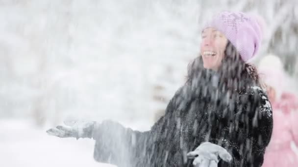 Kvinna och barn leker med snö på vintern — Stockvideo