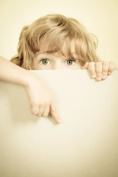 Enfant regardant derrière le papier blanc — Photo