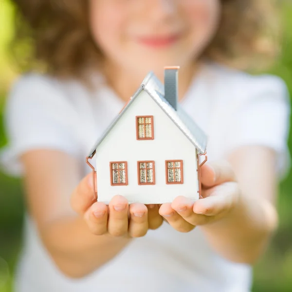 Criança segurando casa — Fotografia de Stock