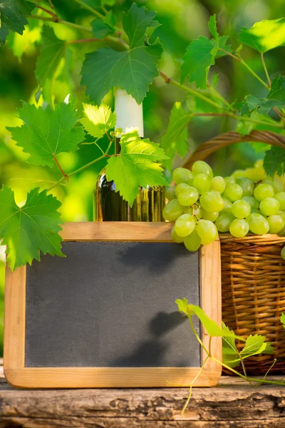 Bando de uvas brancas na cesta e no quadro negro — Fotografia de Stock