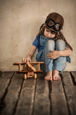 uçak ile oynayan hüzünlü çocuk