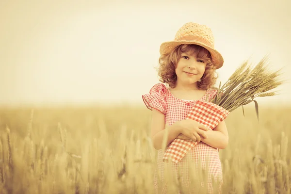 Criança feliz segurando trigo — Fotografia de Stock