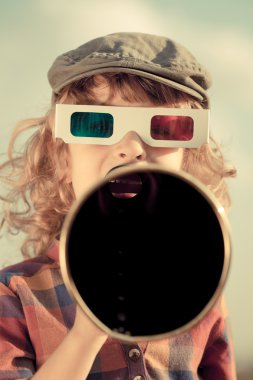 Çocuk megafonla bağırıyor.