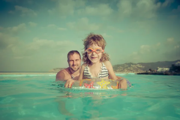 Criança feliz com pai na piscina — Fotografia de Stock