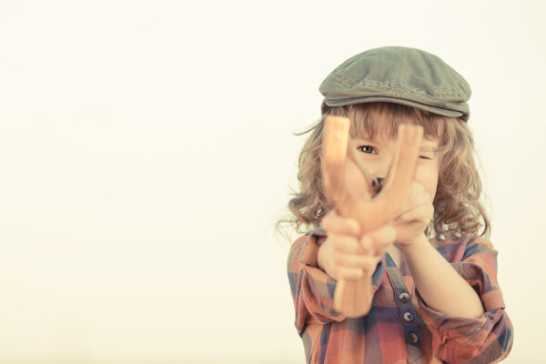 Ребенок держит рогатку
 