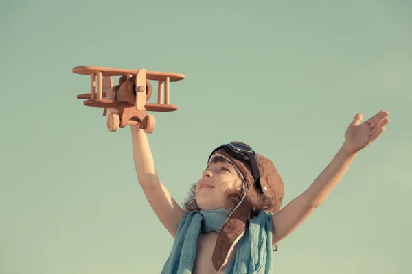 Счастливый ребенок играет с игрушечным самолетом — стоковое фото