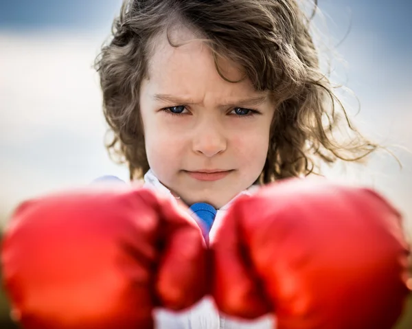 Kid wearing red boxing gloves — Stock Photo, Image