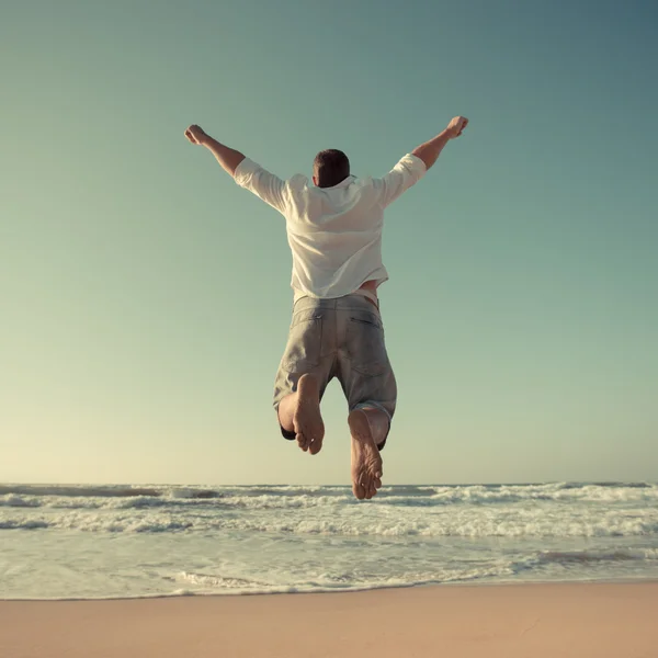 Смішний чоловік стрибає на пляжі — стокове фото