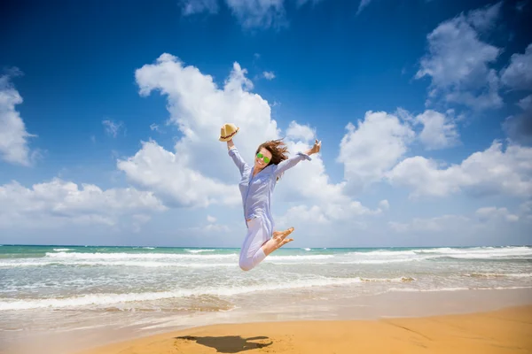 Glad kvinna hoppa på stranden — Stockfoto