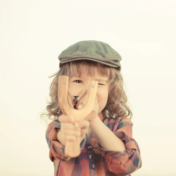 Criança segurando estilingue nas mãos — Fotografia de Stock