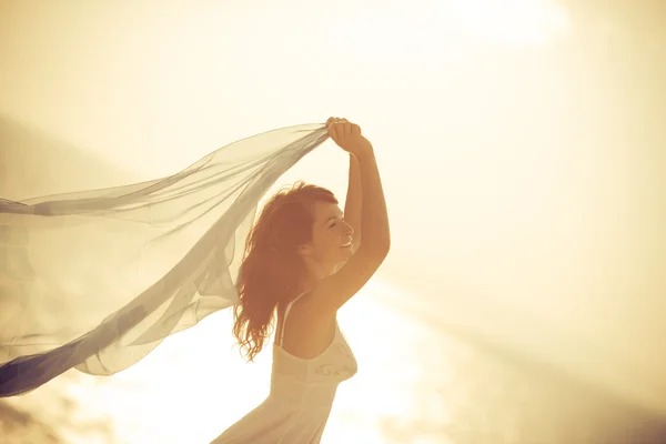 Silhouette einer jungen Frau, die sich am Strand entspannt — Stockfoto