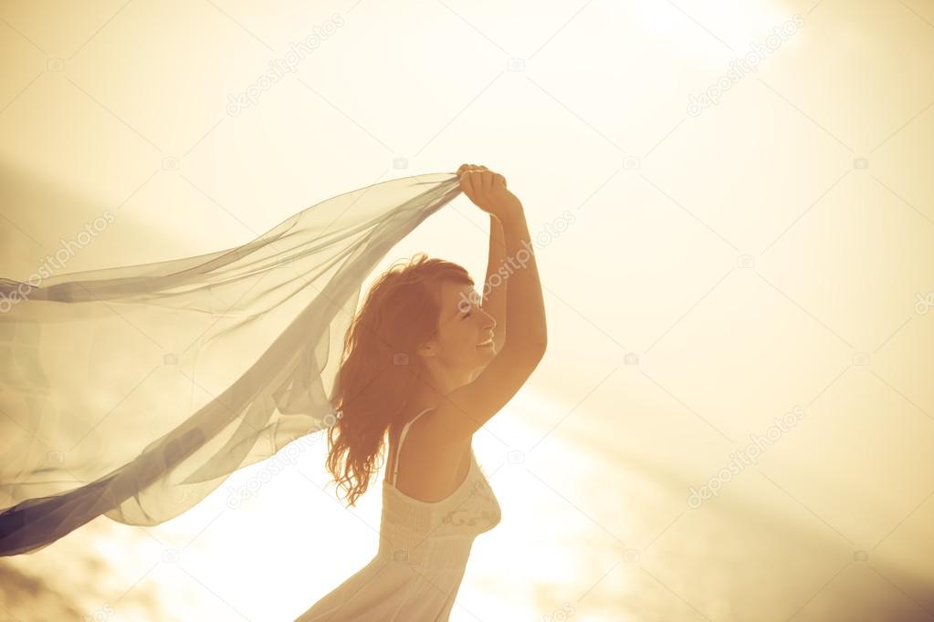 Silhouette of young woman relaxing at the beach