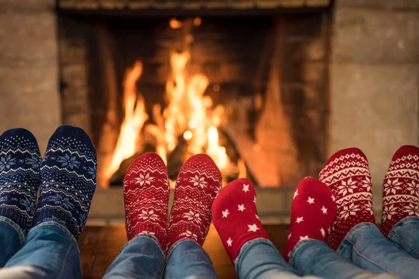 Family in Christmas socks near fireplace. Mother; father and children having fun together. People relaxing at home. Winter holiday Xmas and New Year concept