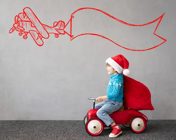 크리스마스 의상을 한아이 장난감 자동차타는 재밌는 아이가 겨울에 밖에서 있는아이 — 스톡 사진