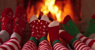 Noel çoraplı aile şöminenin yanında. Anne, baba ve çocuklar birlikte eğleniyorlar. İnsanlar evde dinleniyor. Kış tatili Xmas ve Yeni Yıl konsepti