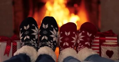 Şöminenin yanındaki Noel çoraplı çift. Erkek ve kadın birlikte eğleniyor. İnsanlar evde dinleniyor. Kış tatili Xmas ve Yeni Yıl konsepti