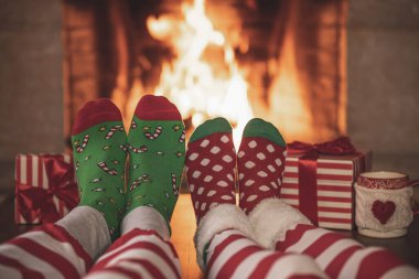 Şöminenin yanındaki Noel çoraplı çift. Erkek ve kadın birlikte eğleniyor. İnsanlar evde dinleniyor. Kış tatili Xmas ve Yeni Yıl konsepti