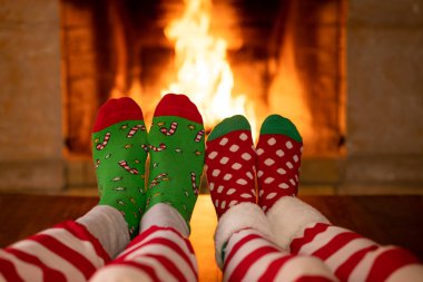 Şöminenin yanındaki Noel çoraplı çift. Erkek ve kadın birlikte eğleniyor. İnsanlar evde dinleniyor. Kış tatili Xmas ve Yeni Yıl konsepti