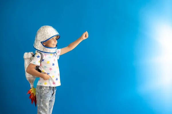 快乐的孩子在蓝色背景下玩玩具火箭 孩子假装是宇航员 想象力与儿童梦想概念 — 图库照片