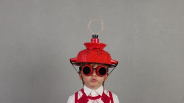 Akıllı çocuk ampullü el yapımı kask takıyor. Komik çocuğun parlak bir fikri var. Eğitim ve iş konsepti. Yavaş çekim 4K