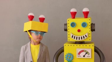 Oyuncak robotla oynayan mutlu çocuk. Komik çocuğun iyi bir fikri var. Yaratıcı, hayal gücü ve bilim konsepti. Yavaş çekim 4K