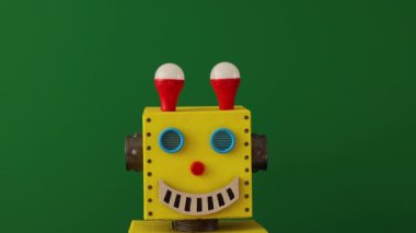 Karton oyuncak robot yeşil karatahtaya karşı. Komik robotun iyi bir fikri var. Yaratıcı, eğitim ve bilim konsepti. Yavaş çekim 4K