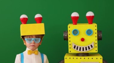 Sınıfta oyuncak robotu olan mutlu çocuk yeşil karatahtaya karşı. Komik çocuğun iyi bir fikri var. Yaratıcı, eğitim ve bilim konsepti. Yavaş çekim