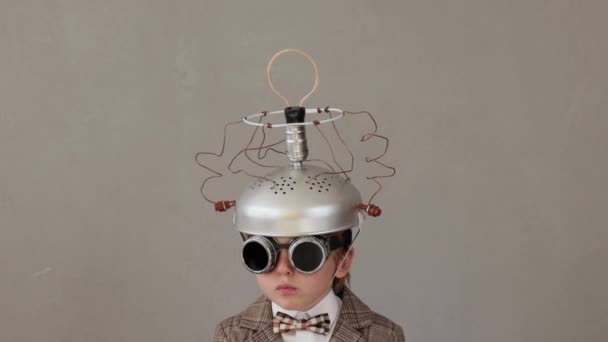 電球で手作りのヘルメットを身に着けているスマート子 面白い子供は明るいアイデアを持っている 教育とビジネスの概念 スローモーション — ストック動画