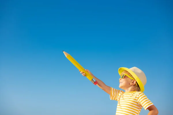 Mutlu Çocuk Mavi Gökyüzü Arka Planına Karşı Kocaman Bir Kalem — Stok fotoğraf
