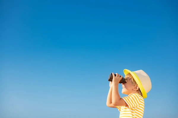 青い空に対して双眼鏡を通して見て幸せな子供 夏に屋外で楽しい時間を過ごしている子供 冒険と旅行のコンセプト — ストック写真