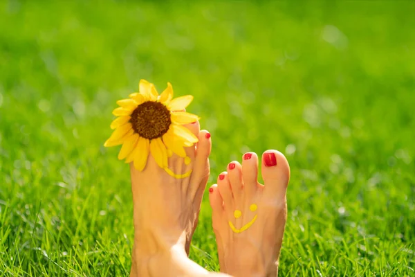 足の屋外で笑顔で幸せな女性 緑の春草の上に横たわる人 生態系と健康的なライフスタイルの概念 — ストック写真