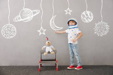 Mutlu çocuk evde oyuncak ayıyla oynuyor. Çocuk astronot gibi davranıyor. Hayal gücü ve çocuklar rüya görür.