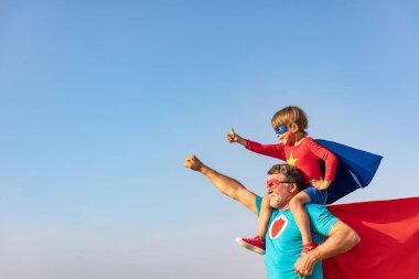 Süper kahraman kıdemli adam ve çocuk dışarıda oynuyorlar. Süper kahraman büyükbaba ve çocuk birlikte eğleniyorlar. Aile tatili konsepti. Babalar günün kutlu olsun.