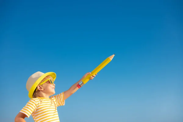 Happy Child Holding Giant Pencil Outdoor Blue Sky Background Portrait — 图库照片