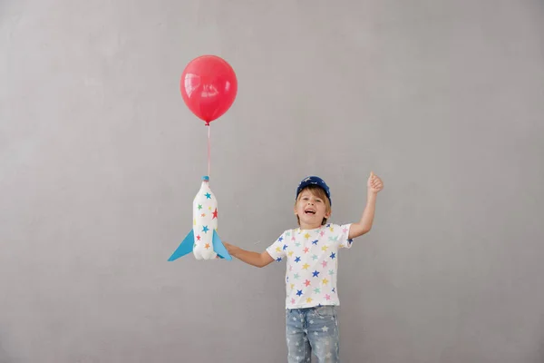 Szczęśliwe Dziecko Bawiące Się Zabawkową Rakietą Domu Dzieciak Udaje Astronautę — Zdjęcie stockowe