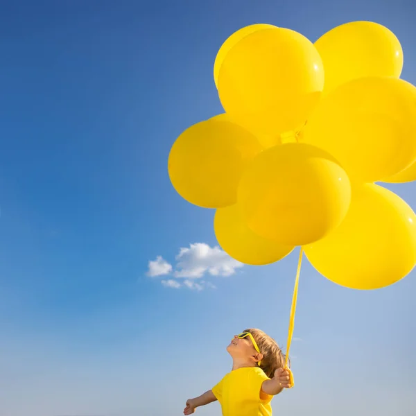 Mutlu Çocuk Dışarıda Sarı Balonlarla Oynuyor Çocuk Mavi Gökyüzü Geçmişine — Stok fotoğraf